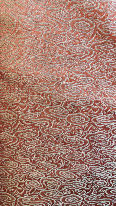 Close-up video of Burgundy coloured fabric with botanical details: delicate floral pattern on burgundy red silk, highlighting the heavy silk drape.