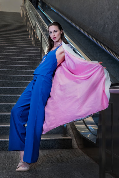 A model stands on stairs, holding open a pink kimono, revealing its soft, luxurious lining. 