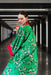 A close-up image of the kimono from the back, showcasing the delicate cherry blossom pattern against the vibrant green mulberry silk background.